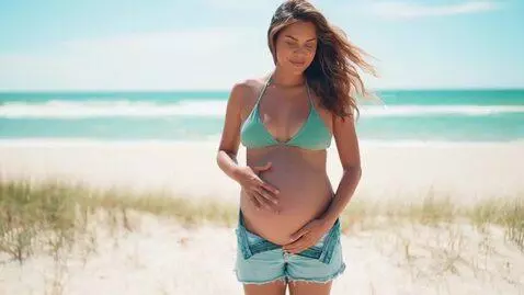 AI Video from prompt: Take a picture of a pregnant woman wearing denim