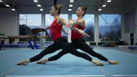 AI Video from prompt: two gymnasts in middle splits, hugging each othe