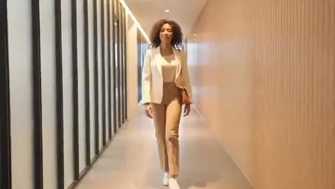 AI Video from prompt: She is walking down the hall now, stopping, spin
