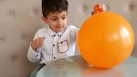 AI Video from prompt: A child pops a large orange balloon with a needl