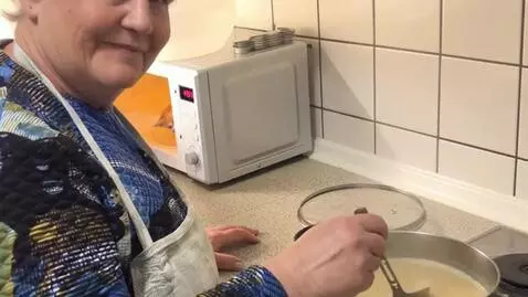 AI Video from prompt: It's the woman in the kitchen, wearing a plaid a