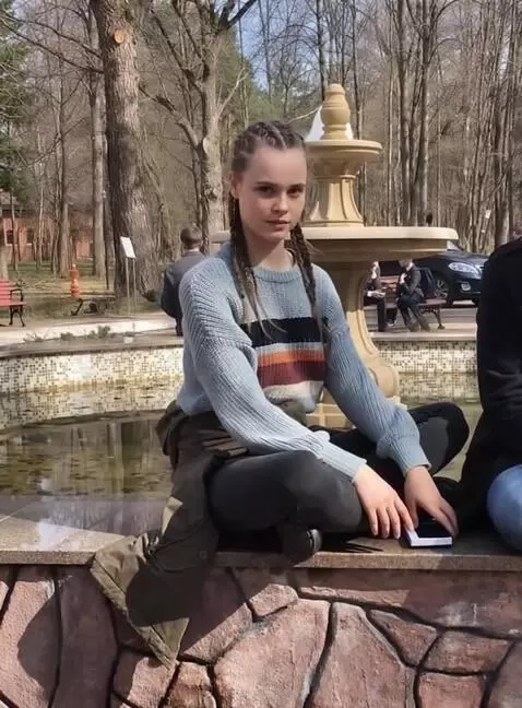 AI Video from prompt: the girl sits almost motionless and looks direct