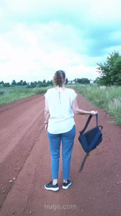 AI Video from prompt: The woman puts back down her backpack,stands wit