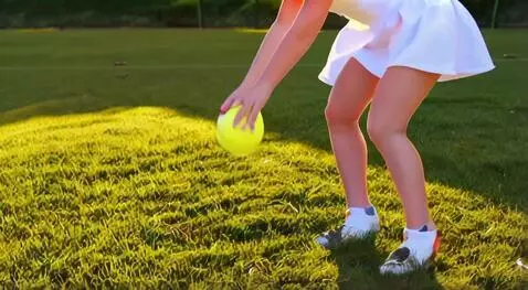 AI Video from prompt: The girl bends down to pick up a tennis ball fro