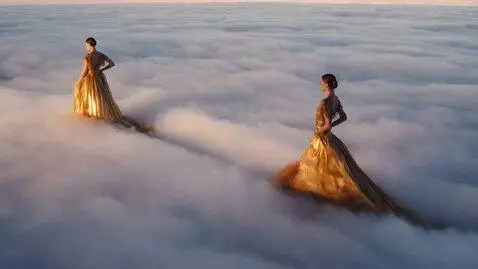 AI Video from prompt: two fashion models walking in clouds wearing sur