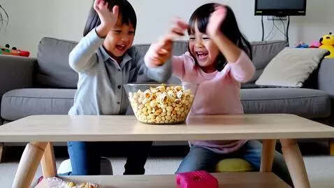 AI Video from prompt: Two kids fighting over a bowl of popcorn