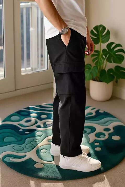 AI Video from prompt: A man wearing black cargo pants slowly turns sid