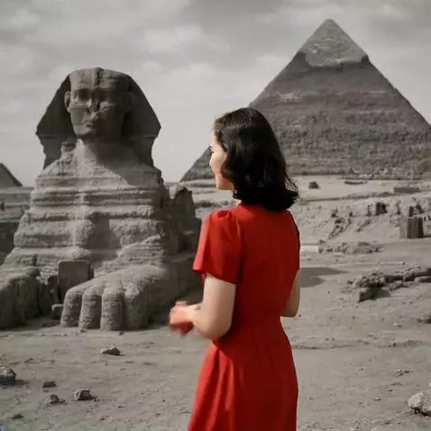 AI Video from prompt: Woman is standing near the Great Pyramids and by