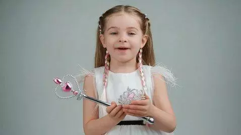AI Video from prompt: The girl shows a crown and then a wand; at the e