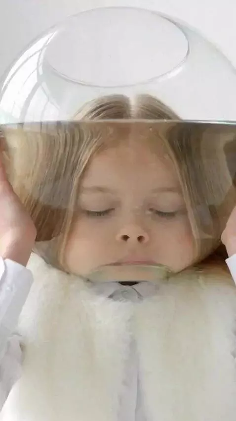 AI Video from prompt: A girl puts a transparent round aquarium with wa