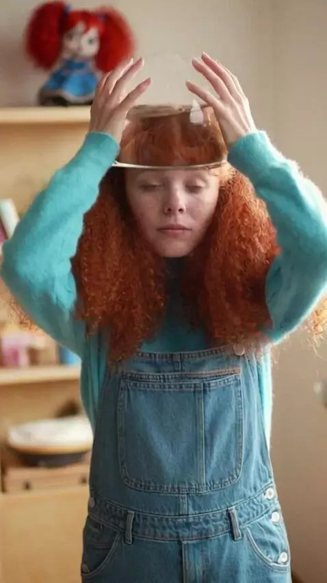 AI Video from prompt: A girl puts a transparent round aquarium with wa