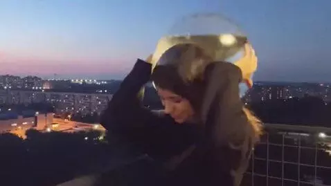 AI Video from prompt: The girl puts a transparent round aquarium with 
