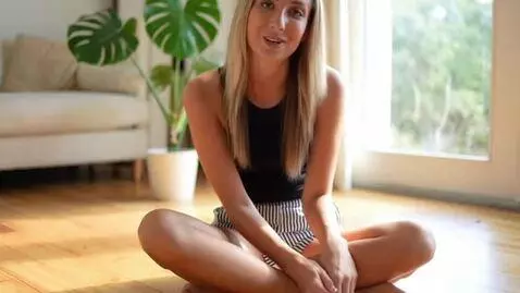 AI Video from prompt: The woman is sitting on a wooden floor with her 
