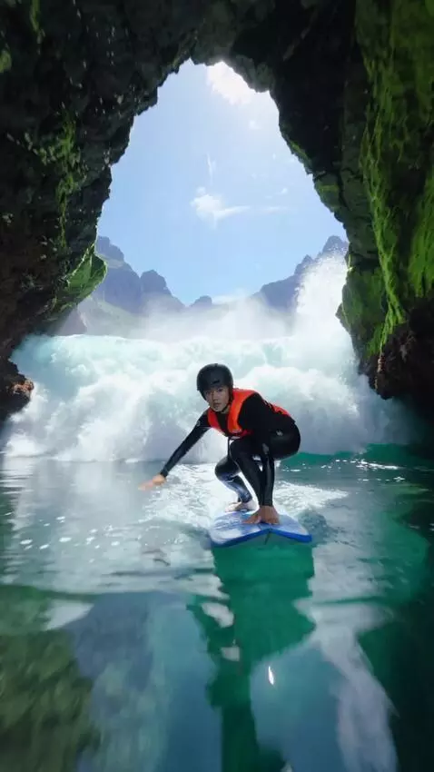 AI Video from prompt: A girl on a blue surfboard rides under a wave in