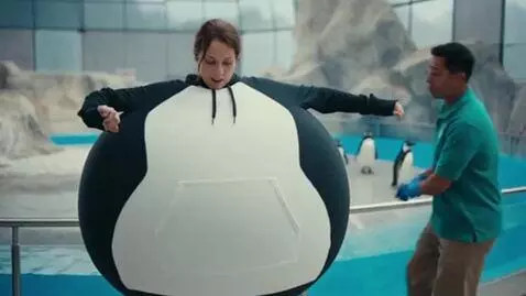 AI Video from prompt: A woman eats a “Puffin Puff Snack” by the pengui