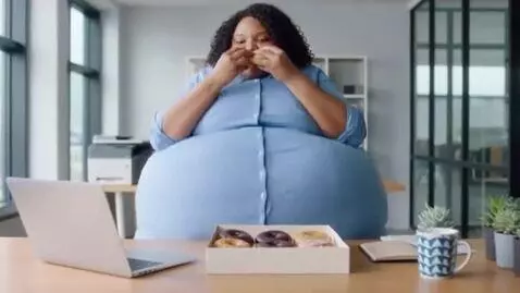 AI Video from prompt: a woman in an office. she eats donuts quickly an