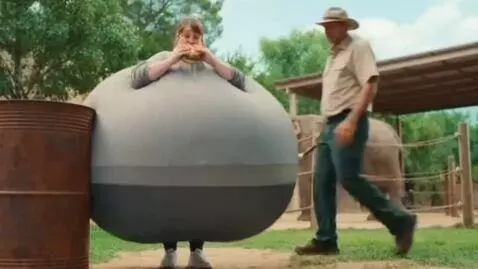 AI Video from prompt: *Action comedy, zoo elephant yard. A woman in a 