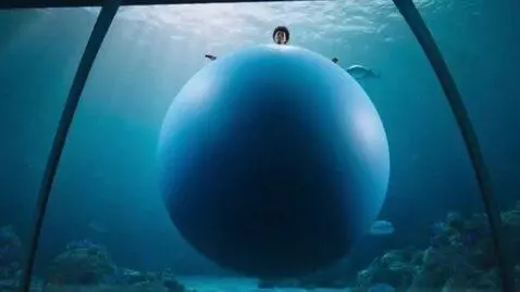 AI Video from prompt: *Aquarium setting, blue ambient light. Woman dre