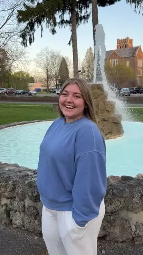 AI Video from prompt: A woman stands near a fountain when her belly sw
