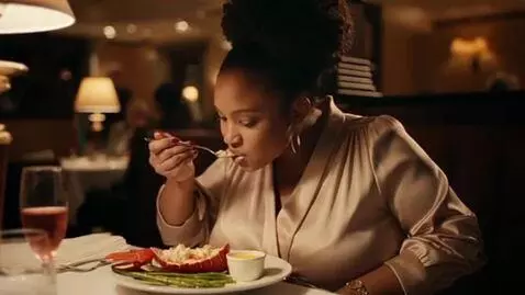 AI Video from prompt: a slim black woman eating at a fancy restaurant.