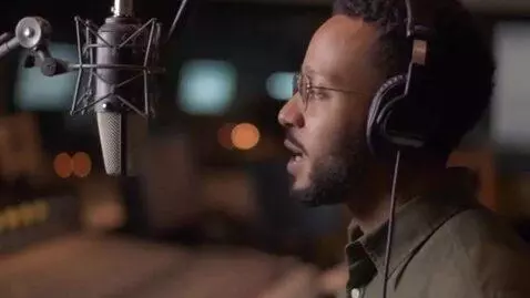 AI Video from prompt: Side view, medium shot] A radio host speaks into