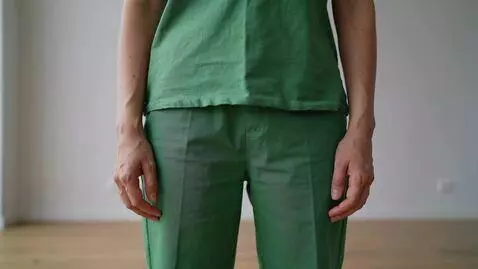 AI Video from prompt: make the person wear the clothes green and pants
