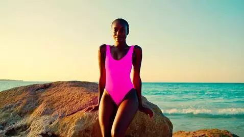 AI Video from prompt: woman with dark skin wearing pink one piece swim