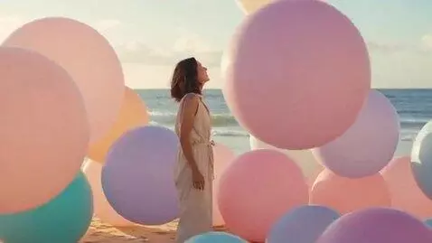 AI Video from prompt: a woman at the beach becomes enormous and puffy.
