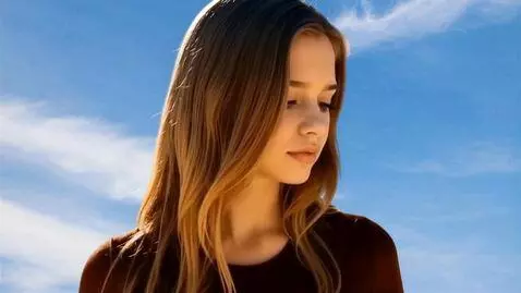 AI Video from prompt: Image of a young woman's serene face. She looks 