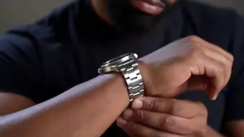 AI Video from prompt: Muscular man putting a masculine metal wristwatc
