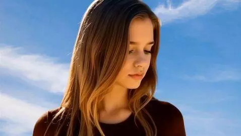 AI Video from prompt: Image of a young woman's serene face. She looks 