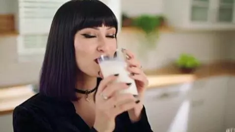 AI Video from prompt: a thicc goth woman drinks a gallon of milk. her 
