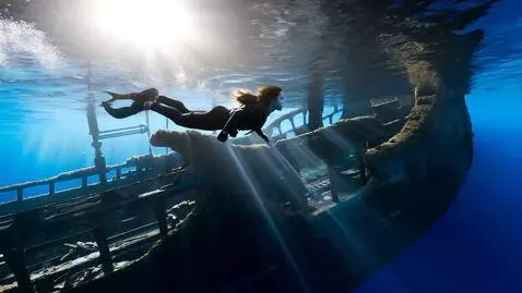 AI Video from prompt: Underwater shot: Lara Croft in black diving suit
