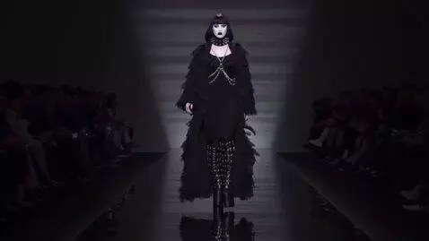 AI Video from prompt: a goth model on a runway. she reaches the end of