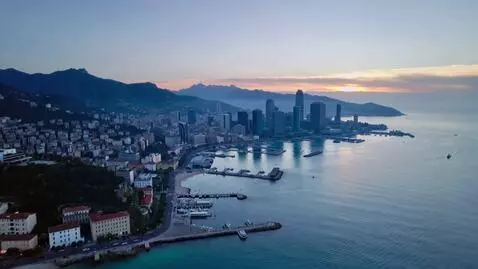 AI Video from prompt: Dawn over the city with the sea, the camera flie