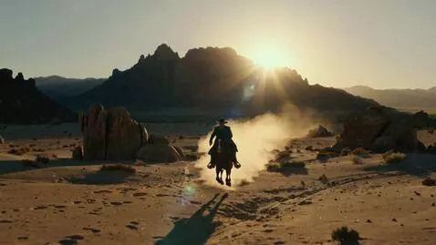 AI Video from prompt: we see a cowboy a villain, on horseback in the d