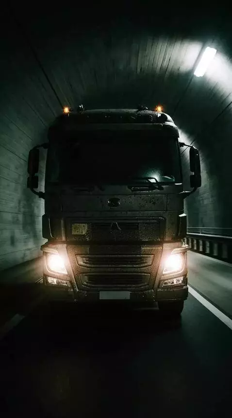 AI Video from prompt: A heavy truck with its headlights on is rushing 