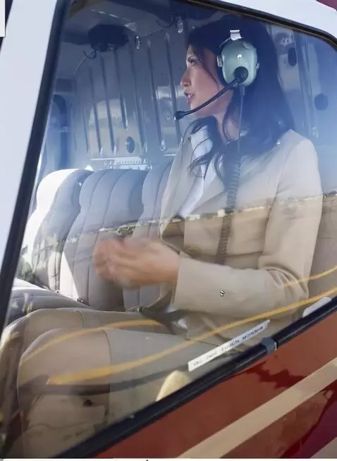 AI Video from prompt: A female correspondent sits in a helicopter, ani