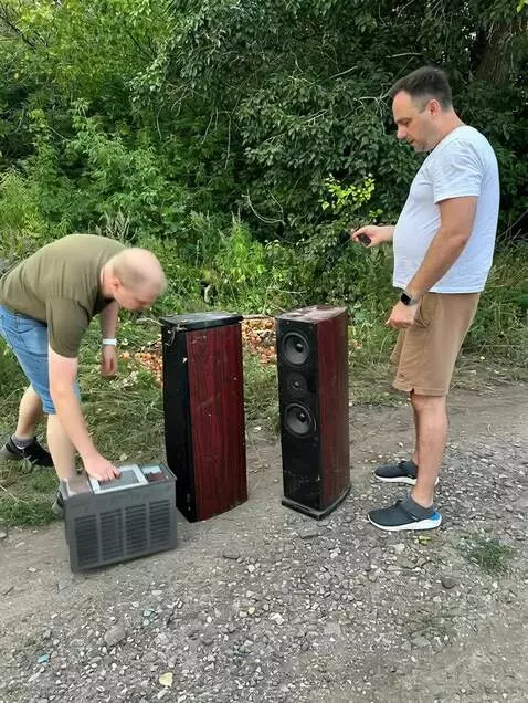 AI Video from prompt: Два мужчины берут каждый по одной колонке на пле