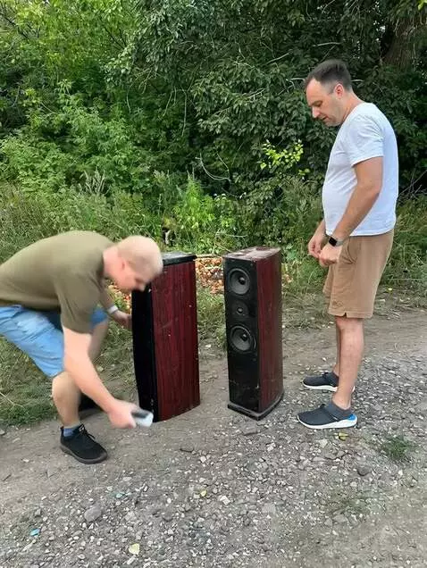 AI Video from prompt: Два мужчины берут каждый по одной колонке и выбр