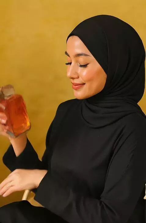 AI Video from prompt: A graceful woman in a black hijab sits elegantly