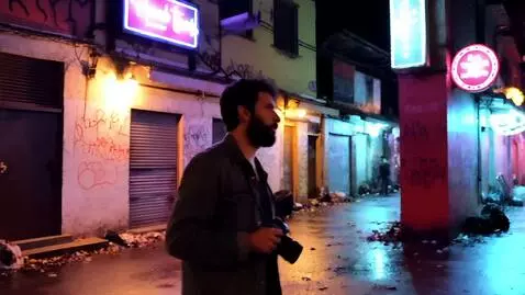 AI Video from prompt: A street photographer wanders the nighttime alle