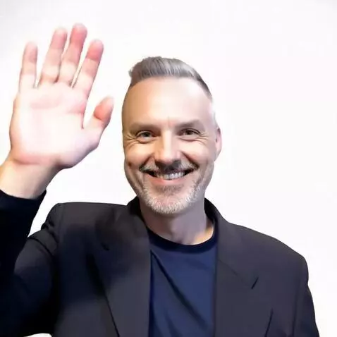 AI Video from prompt: Have the man smile then wave and then turn into 