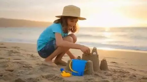 AI Video from prompt: A 7yo girl, playing in the sand at a beach.
