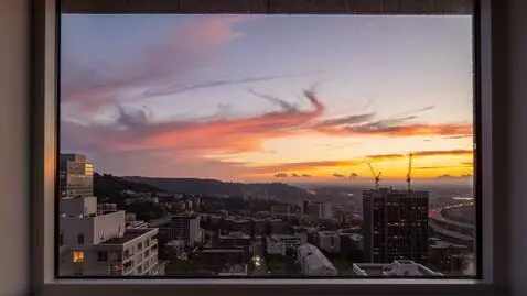 AI Video from prompt: Take a sunset view from a 9th-floor apartment wi