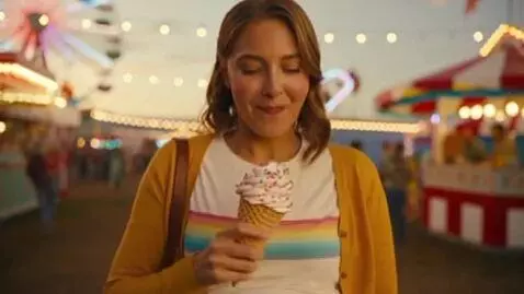 AI Video from prompt: a woman eats an ice-cream cone from the fair. sh