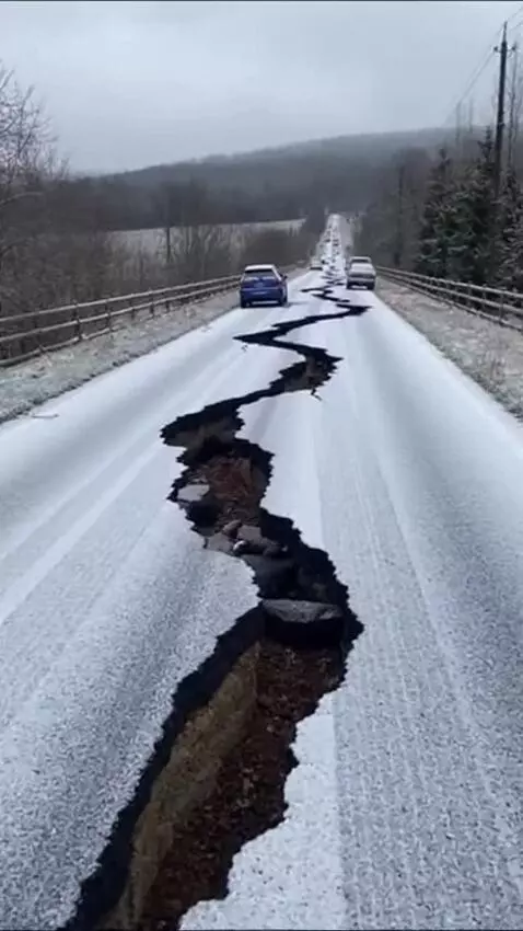AI Video from prompt: The image shows a road with a large crack runnin