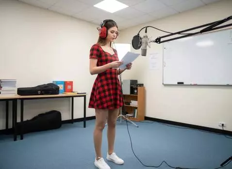 AI Video from prompt: A young woman in a recording studio. Listening t