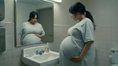AI Video from prompt: A pregnant woman nervously looks at herself in t