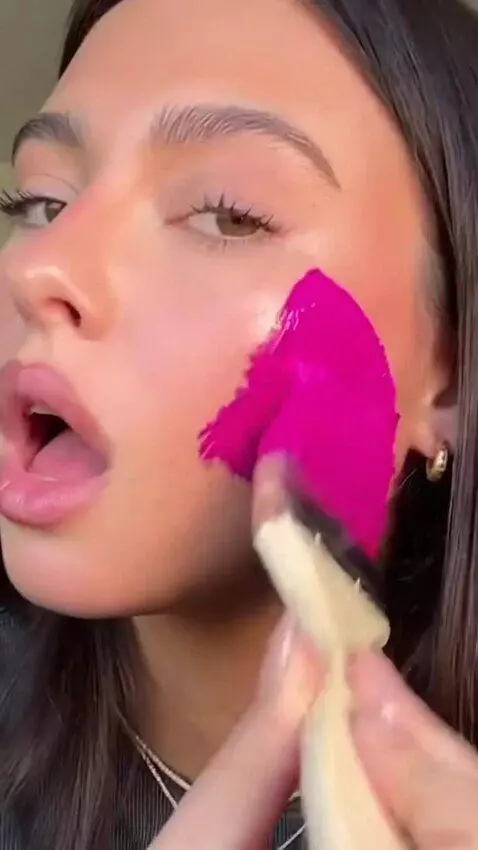 AI Video from prompt: A girl holds a big paintbrush in one hand and a 